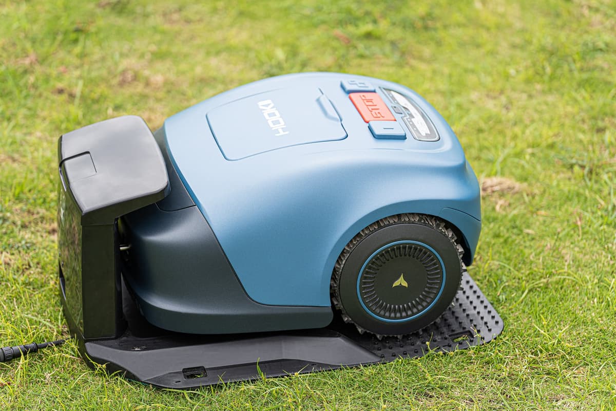 Wire-free robot mower parked on its charging station on a lawn